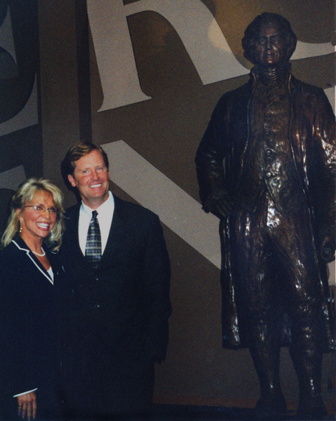 Group of officials standing beside the unveiled bronze statue of Thomas Jefferson at a public ceremony.