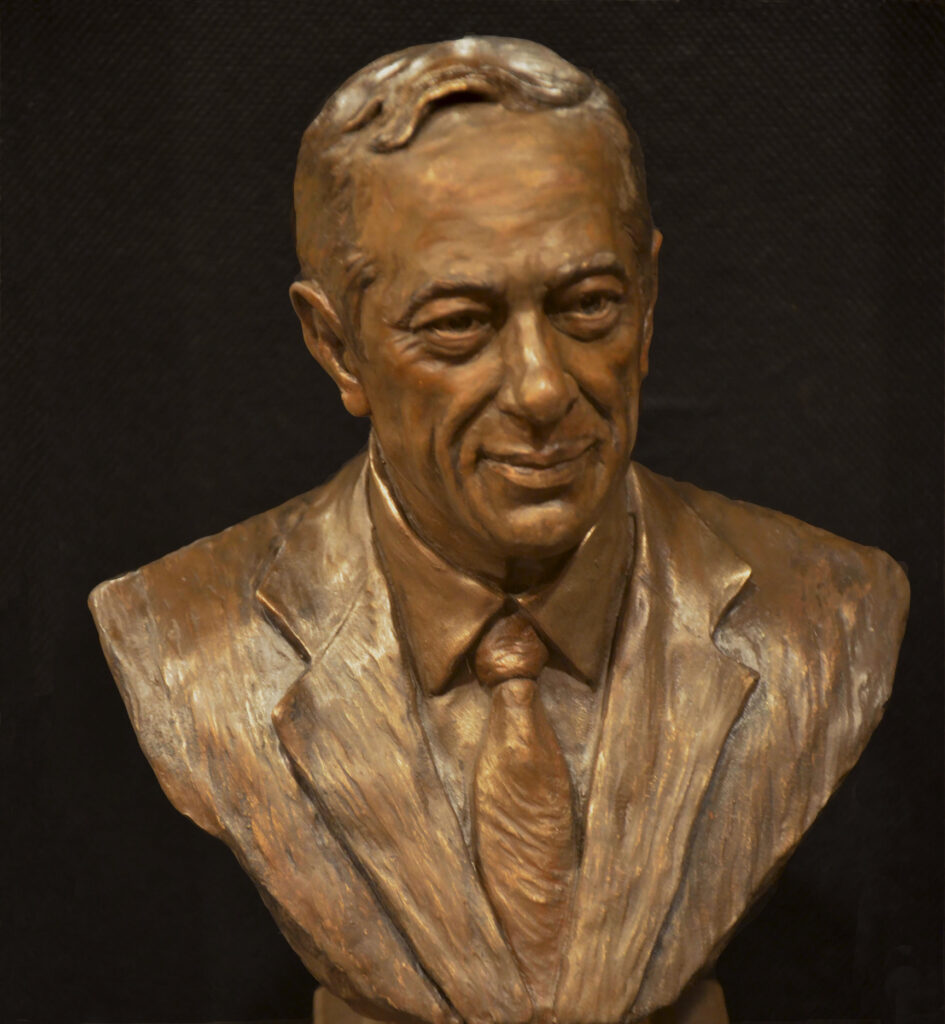 Close-up view of a bronze bust of Mario Cuomo, emphasizing facial expression and textured surface of the sculpture.