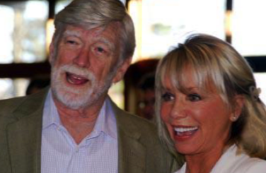 David Roosevelt and Carolyn Palmer standing together indoors during an unveiling event, smiling toward the camera.