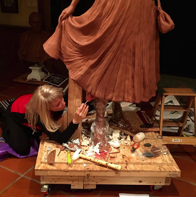 Sculptor Carolyn D. Palmer working on the lower portion of the clay Lucille Ball figure in her studio.